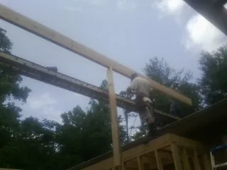Carpenter setting a ridge beam over a new addition frame — Ice Dam Removal by Roofing Brothers in Jenkinsburg