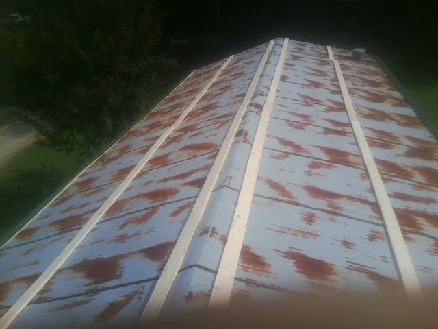 Rusted metal roof panels with new wood purlins before replacement — Storm Damage Roof Repair in Jenkinsburg by Roofing Brothers