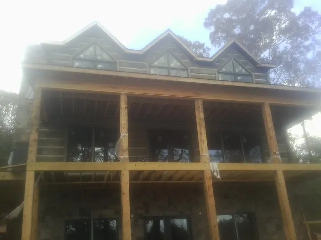 Dormers and porch framing on a large log home under construction — Roof Coating work by our crew in Jenkinsburg