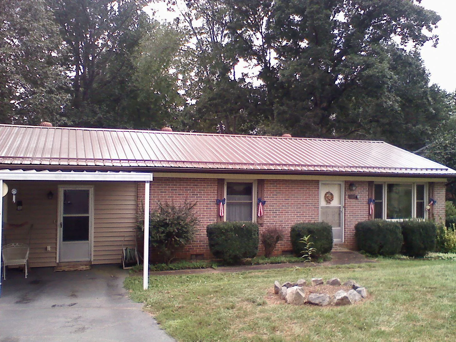 Bronze metal roof and carport on a brick ranch home — Roof Repair work by our crew in Jenkinsburg